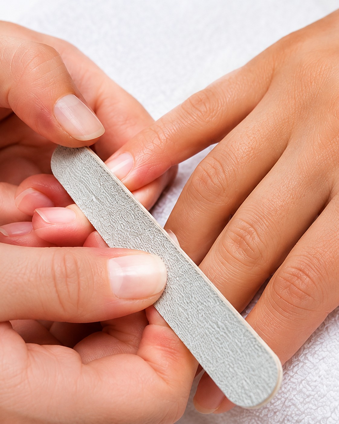 Fingernägel werden mit einer Feile in Form gebracht